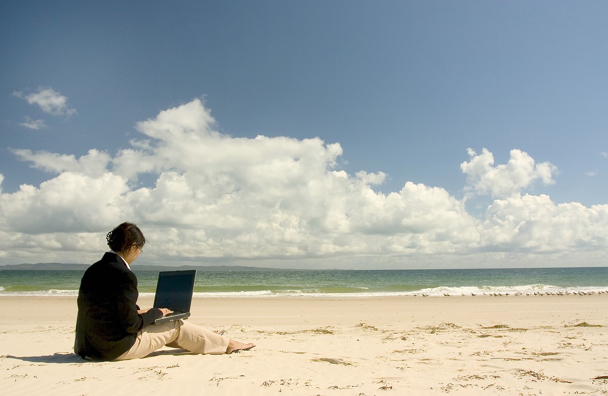 Person on beach with laptop computer
